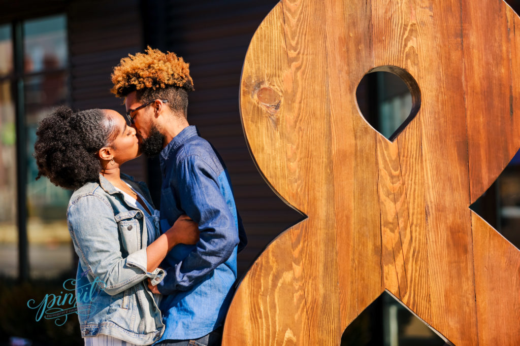 couple kissing next to an ampersand 