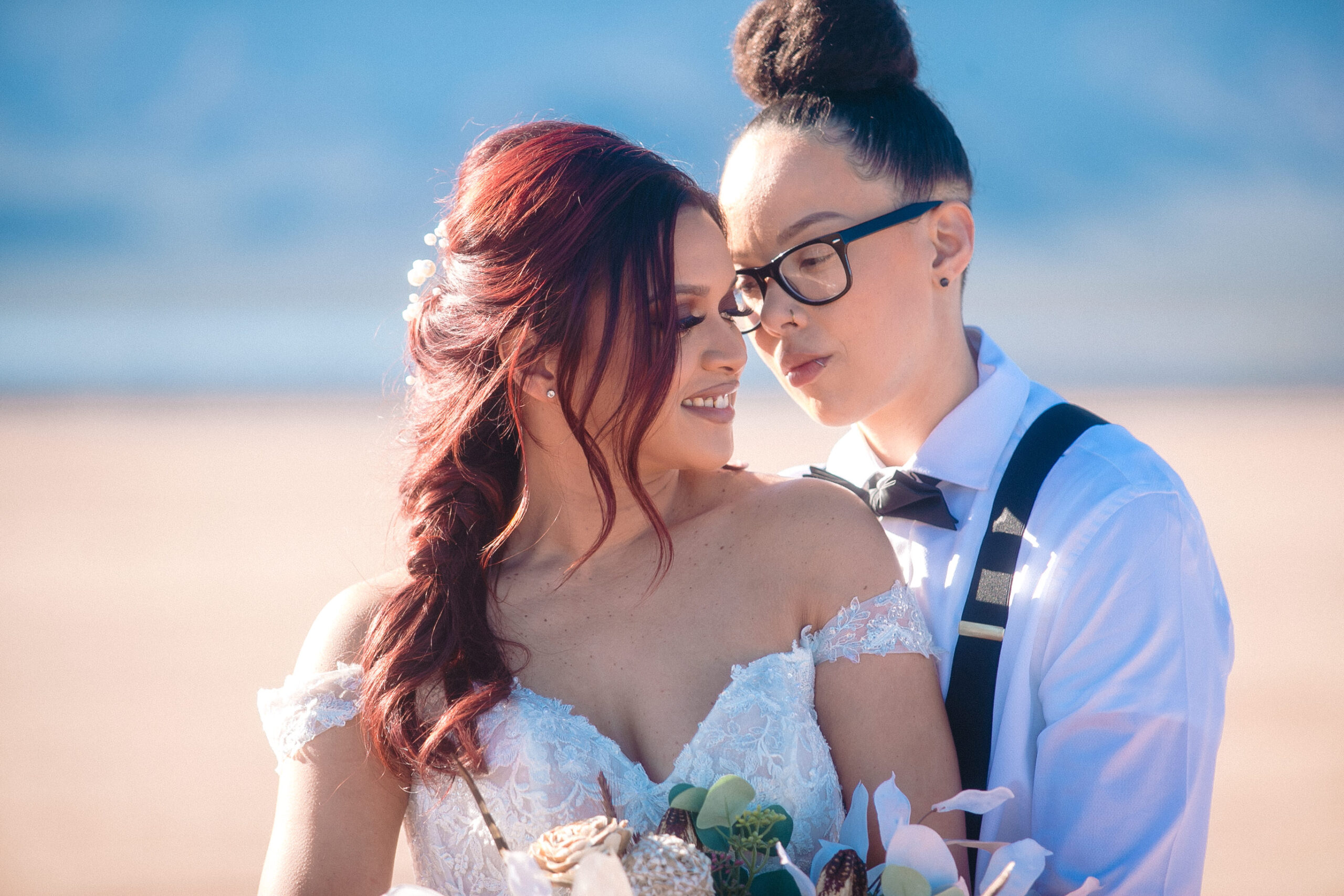 same sex couple posing with mountain far in the background